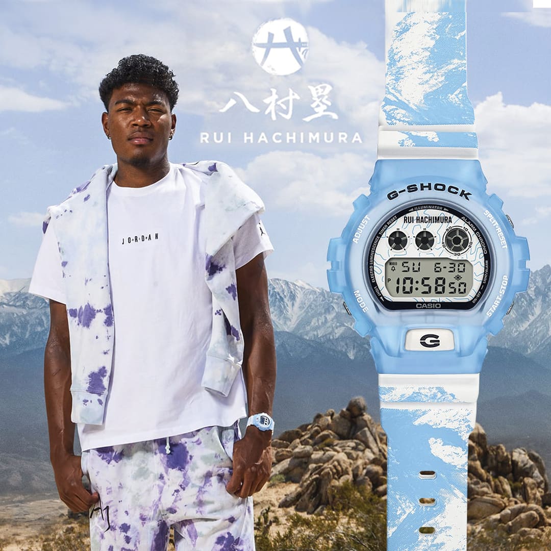 Rui Hachimura wearing his signature watch DW6900RH-2 with mountain range and skyline in the background which is the inspiration of the band design