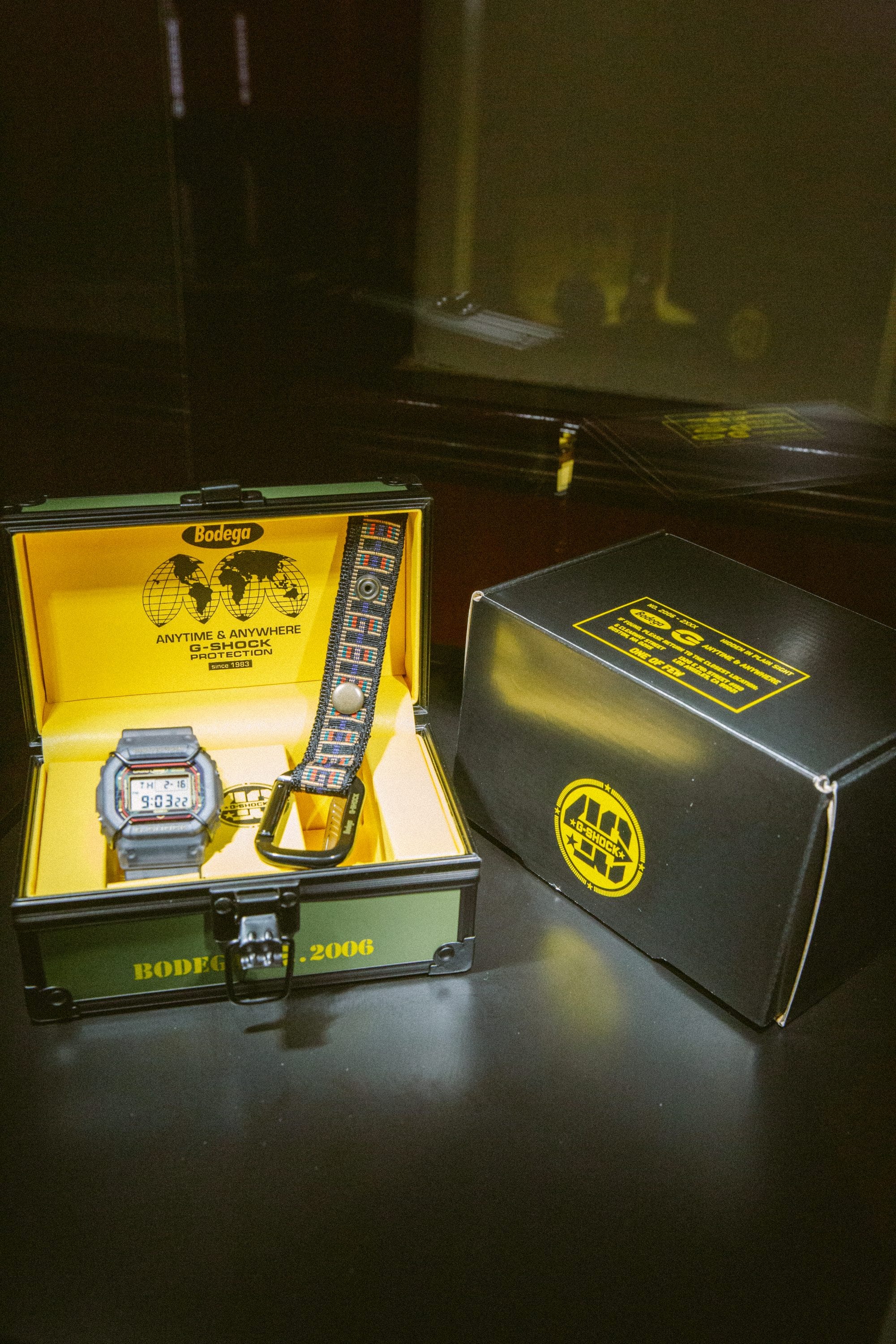 Shot of the Bodega x G-SHOCK DW5600BDG23-1 watch and accessories presented in the special packaging and outer box