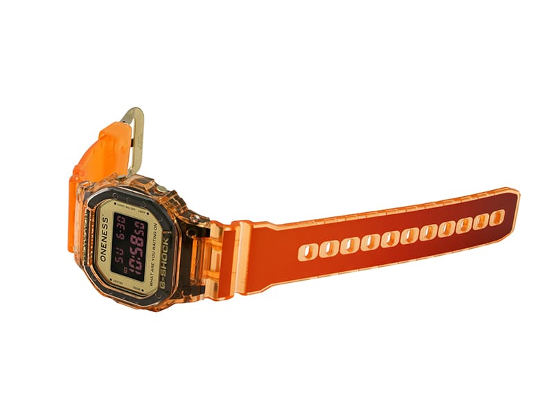 Shot of G-SHOCK x Oneness DW5600ONS23-4 laid on its side displaying the light orange to dark orange gradient of the watch