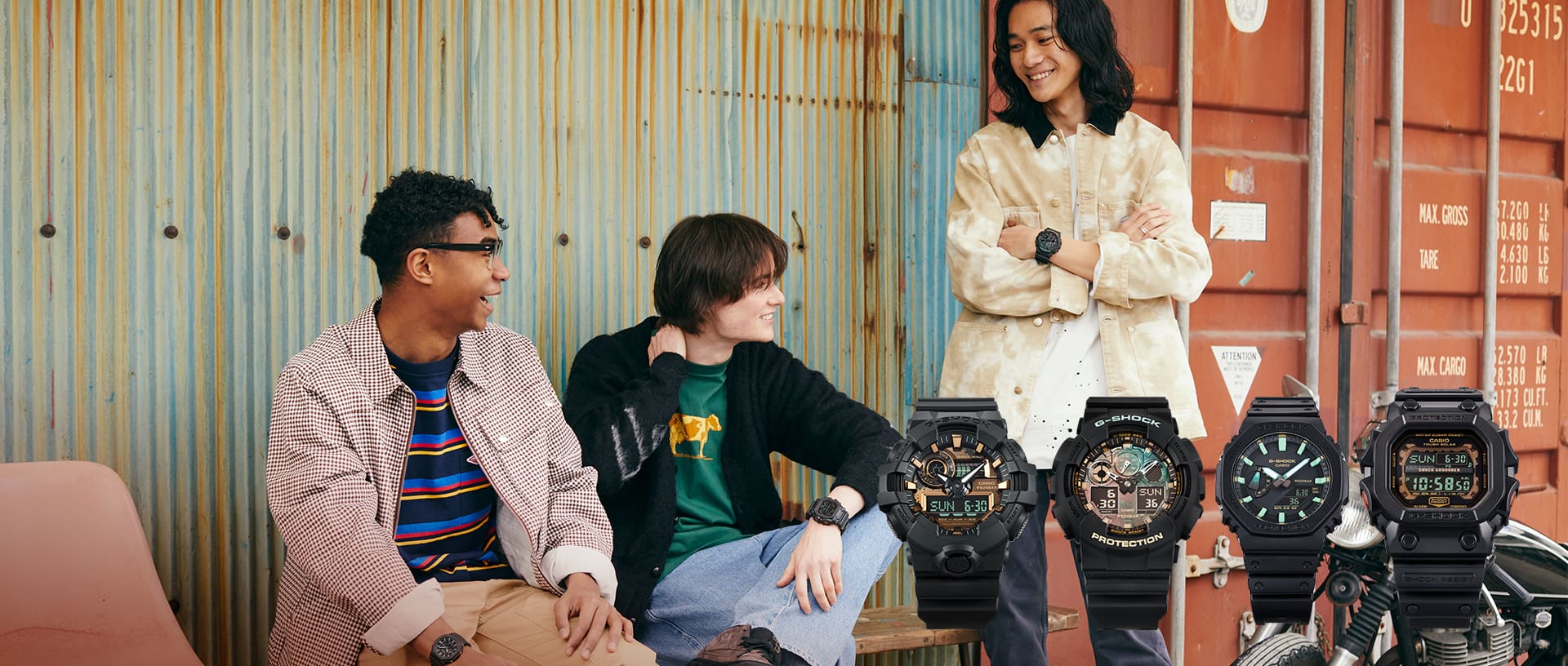 Group of friends sitting by a some rusted shipping containers wearing black and rust colored G-SHOCK watches