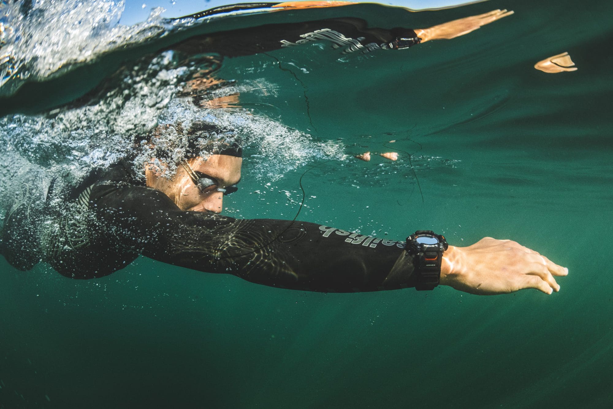 man wearing black G-SHOCK MOVE GBDH2000-1A swimming in the ocean
