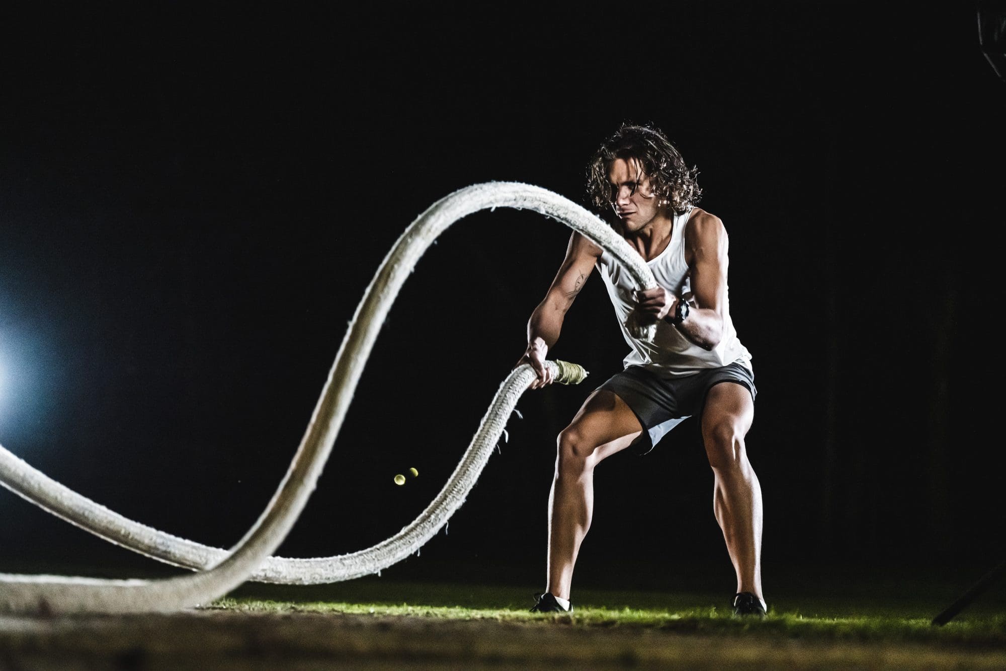 man wearing black G-SHOCK MOVE GBDH2000-1A doing battle ropes exercise