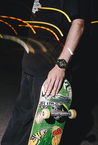 Skateboarder wearing a G-SHOCK Caution Yellow watch in the dark