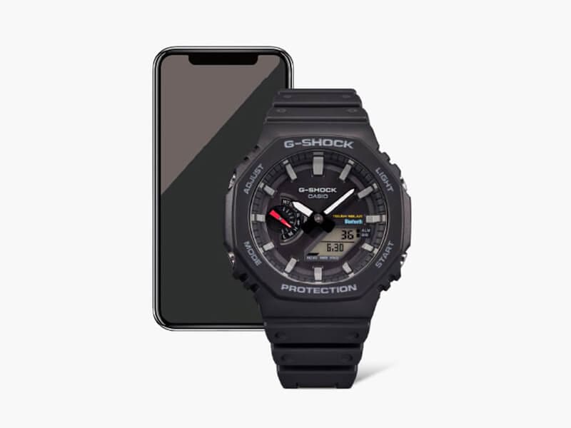 Black G-SHOCK GAB2100 analog digital watch with mobile device in the background 