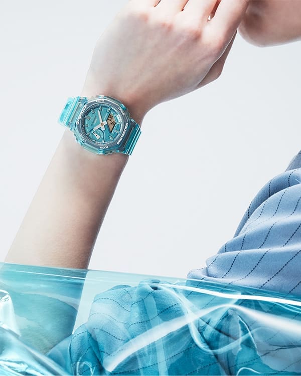 Close up of model's wrist in blue clothes posing with blue transparent GMAS2100SK