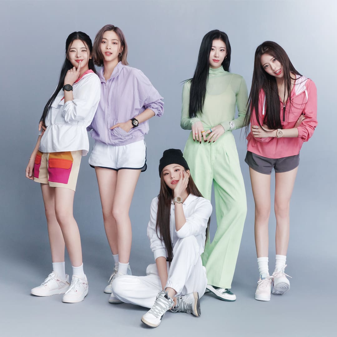 ITZY Band Members posing in front of a gray back drop
