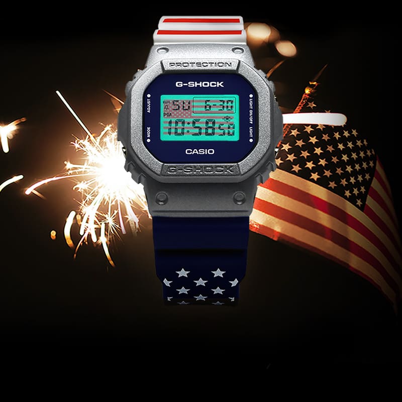 American Flag inspired DW5600US23-7 watch with fireworks sparkler and American flag in the background.
