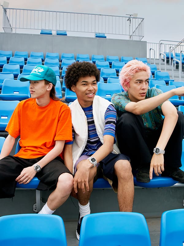 Group of friends wearing G-SHOCK Clear Remix watches sitting in the bleachers
