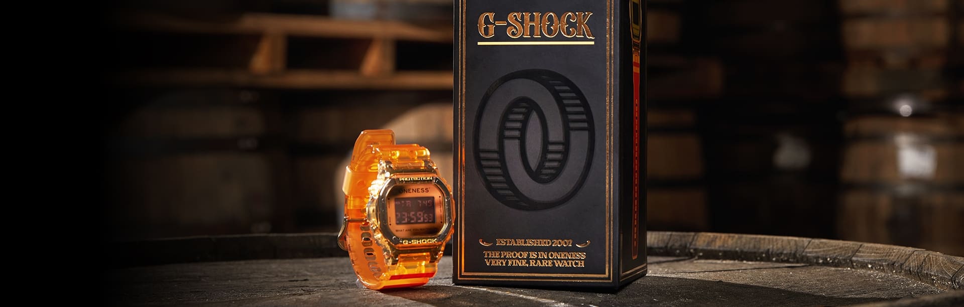 G-SHOCK x Oneness DW5600ONS23-4 next to special packaging atop of a Kentucky bourbon barrel