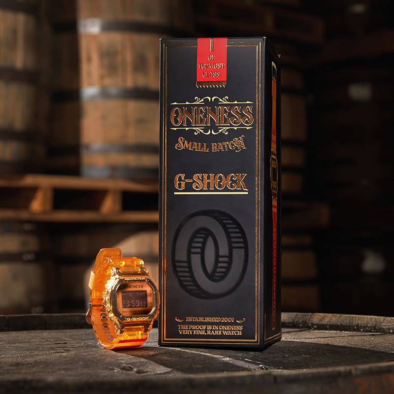 G-SHOCK x Oneness DW5600ONS23-4 next to special packaging atop of a Kentucky bourbon barrel