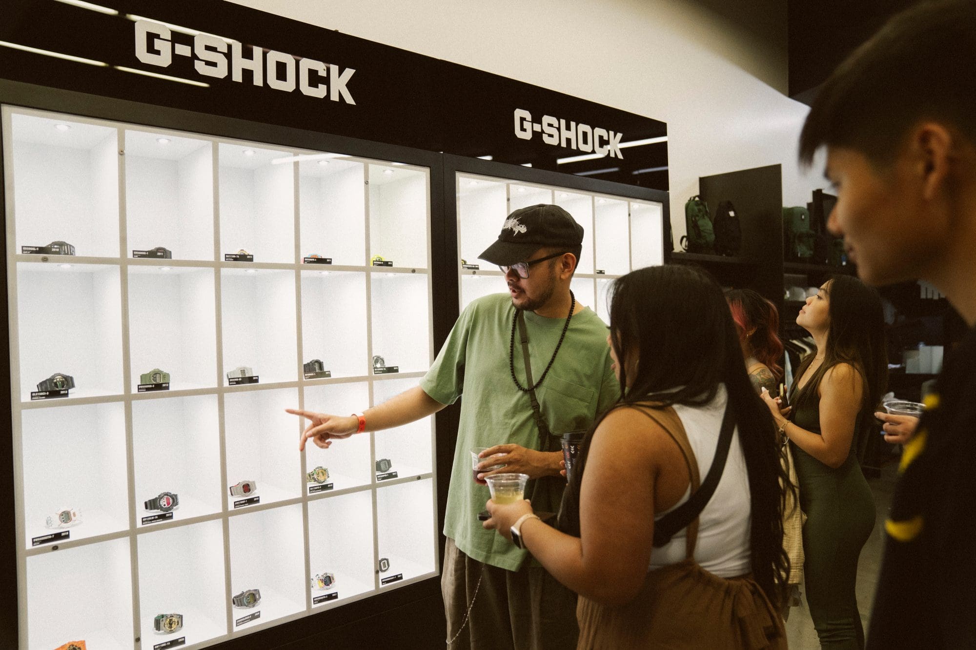Attendees viewing G-SHOCK History Wall at the UNDEFEATED x G-SHOCK pre-launch event at UNDEFEATED Silver Lake