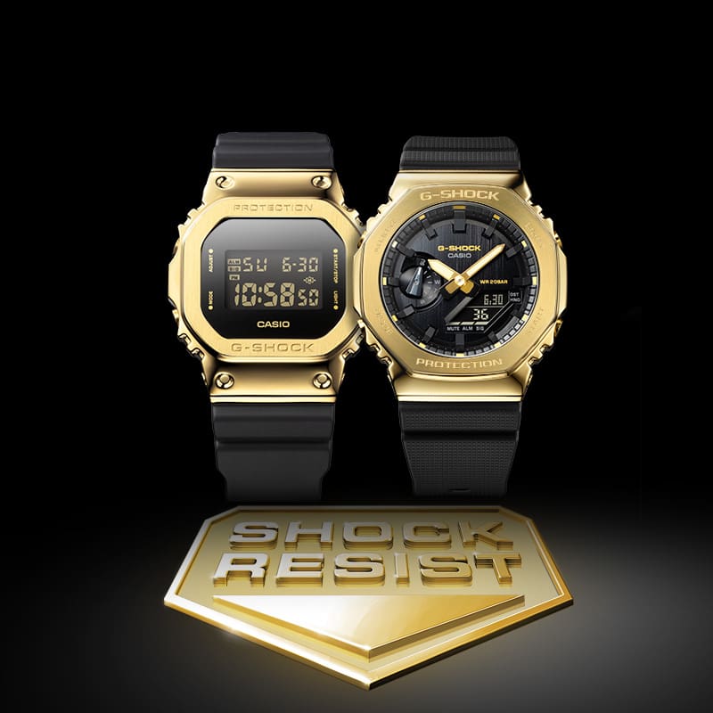GM-2100G-1A9 Analog Digital and GM-5600G-9 Digital gold watches with black bands next to shock resist badge